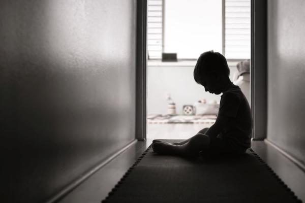 smutné malé dítě sedící v chodbě