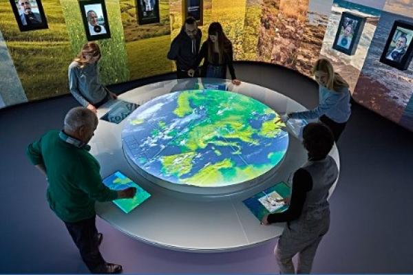 Lidé v interaktivním prostoru prohlížející si na interaktivní mapě Evropu